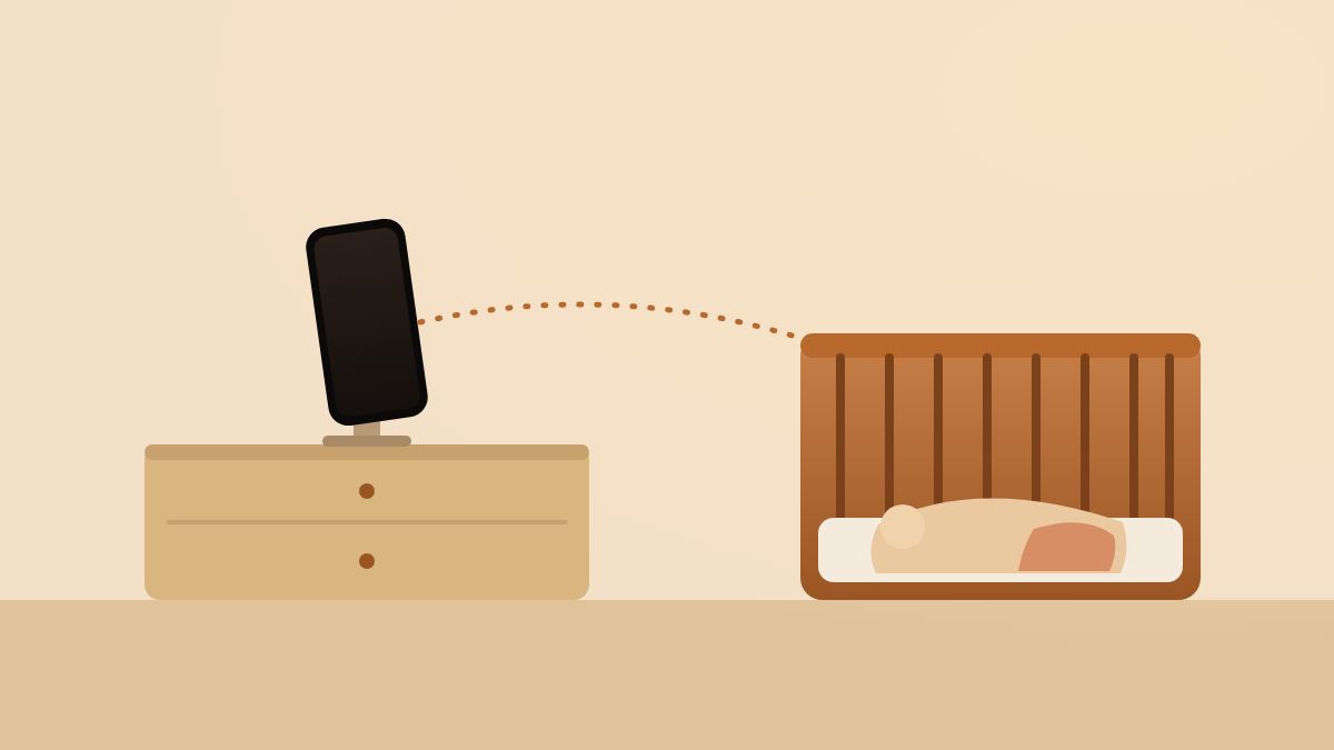 A phone on a small stand on a dresser, aimed at a crib across the room